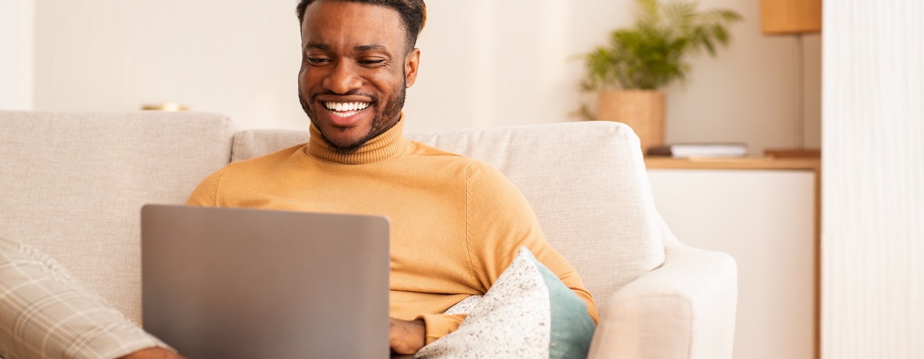 a man sitting on a couch with a laptop