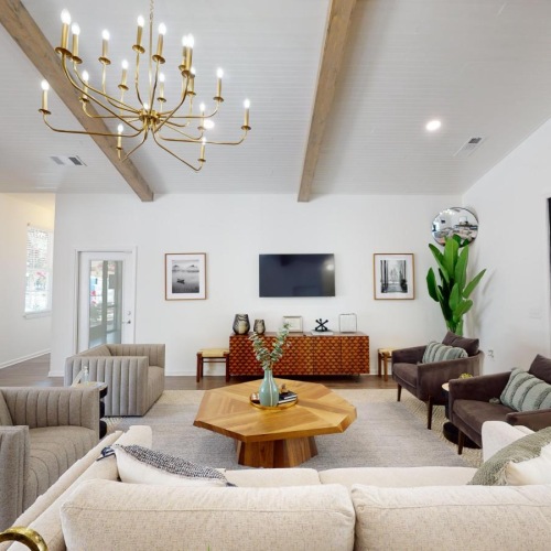 a clubroom with a couch, tables and chairs